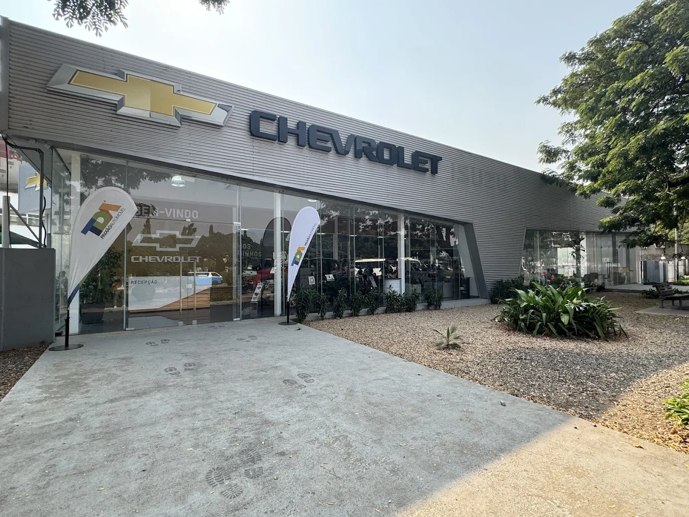 Fachada do stand Chevrolet da TDA em Angola, com logotipo da marca e bandeiras institucionais na entrada.